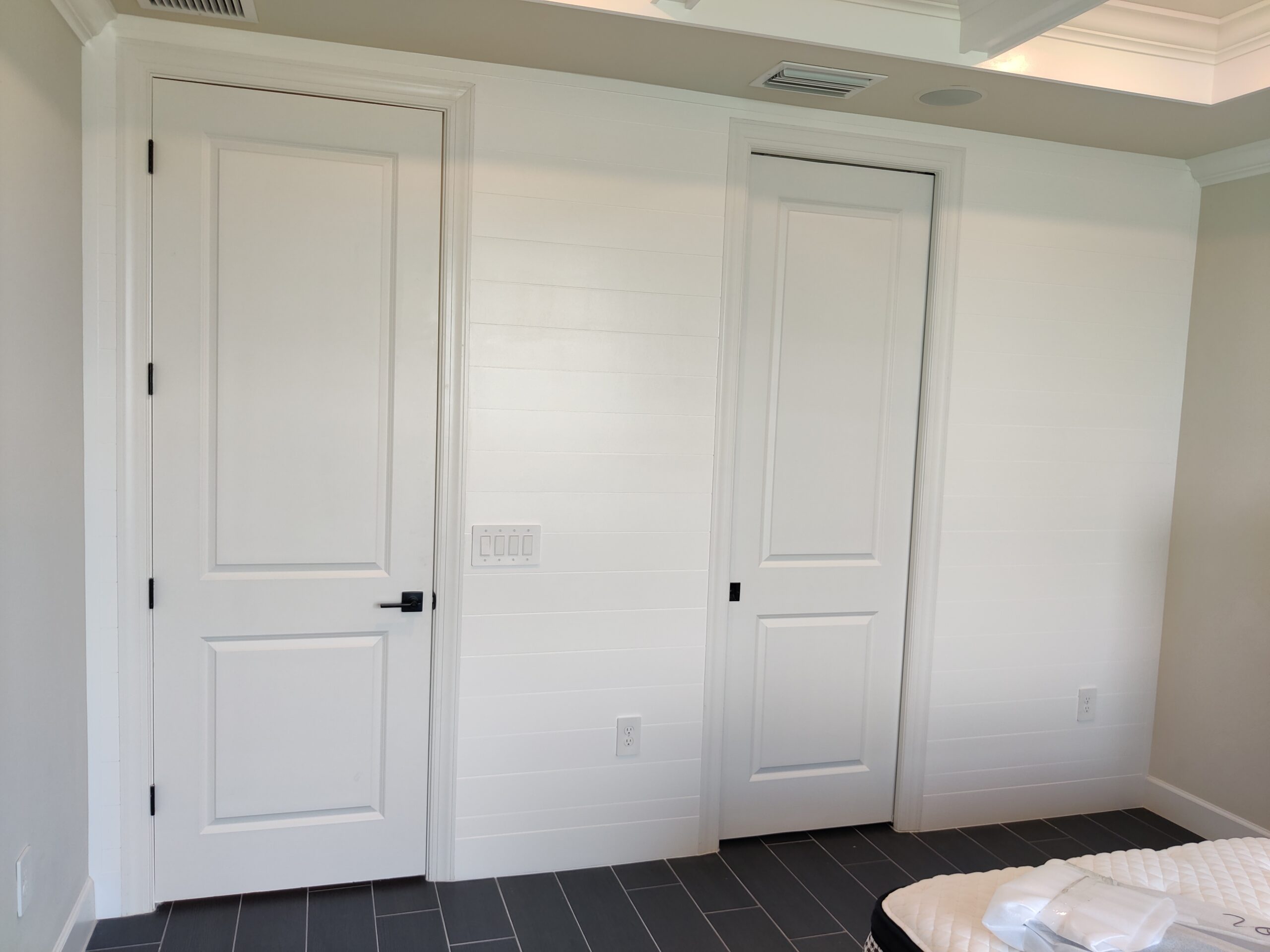 Final project photos for Yellowfin in Naples, Florida, featuring traditional wainscoting, unique wainscoting on an accent wall, crown molding, a shiplap bedroom wall, and a coffered ceiling.